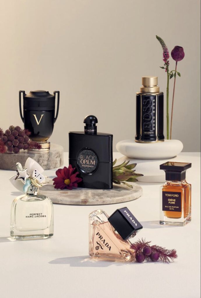 Colección de perfumes originales y fragancias de lujo exhibidos en una mesa con estilo elegante y moderno.